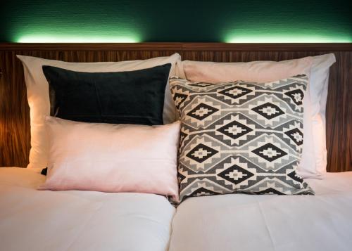 a group of pillows sitting on top of a bed at Linden Hotel in Amsterdam