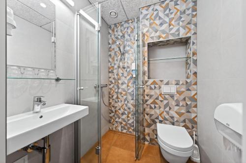 a bathroom with a toilet sink and a shower at Värska Veekeskuse hotell in Väike-Rõsna
