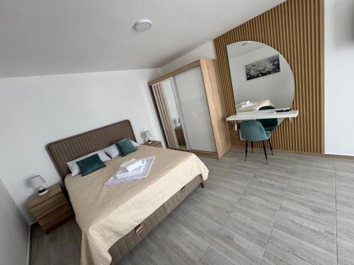 a bedroom with a bed and a desk and a mirror at Andrej Apartmani Rafailovici in Rafailovici