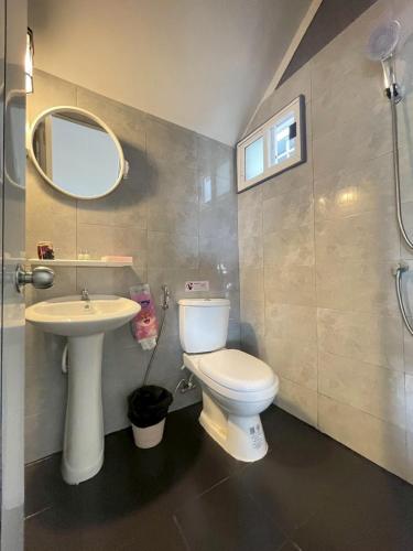 a bathroom with a toilet and a sink and a mirror at Grace Riverfront Villa Near Suvarnabhumi Airport in Lat Krabang