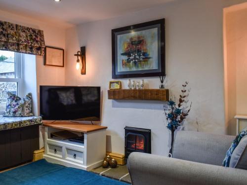 a living room with a tv and a fireplace at Byways in Cartmel