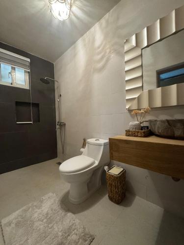 a bathroom with a toilet and a sink and a mirror at Villa danexia in Juan Dolio