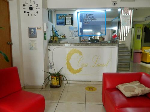 a waiting room with two red chairs and a counter at Casa Laurel in Cancún