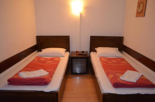 two beds sitting next to each other in a room at Complex Parc Pini Moinesti in Moineşti