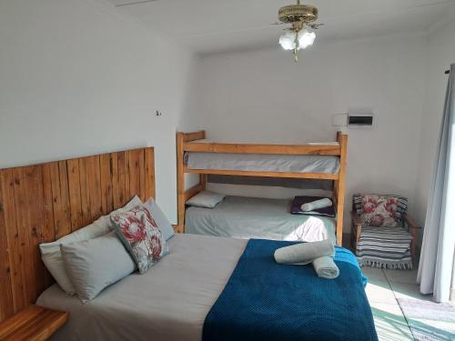 a bedroom with a bed and a bunk bed at Ons Dorpshuis Beaufort West in Beaufort West