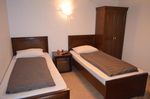a bedroom with two beds and a night stand at Complex Parc Pini Moinesti in Moineşti