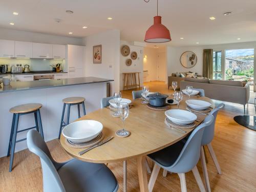 a dining room and kitchen with a wooden table and chairs at Lodge 53 Una in Carbis Bay