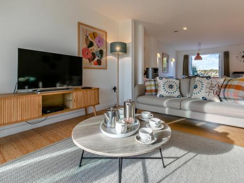 a living room with a couch and a tv at Lodge 53 Una in Carbis Bay