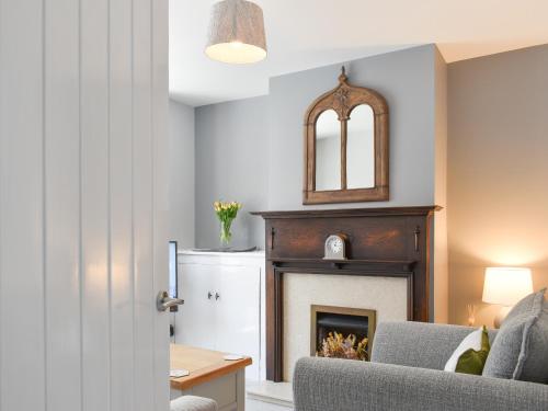 a living room with a fireplace and a chair at Newstead Cottage in Weymouth