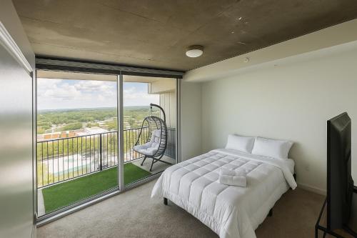 a bedroom with a bed and a large window at Condo in downtown oak city highrise in Raleigh