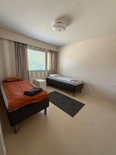 a bedroom with two beds and a window at Loft house Karihaara in Kemi