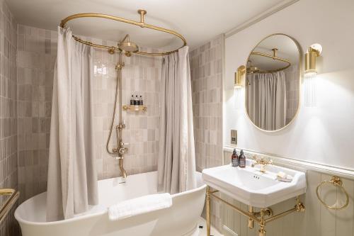 a bathroom with a tub and a sink and a mirror at Flodigarry Hotel in Staffin