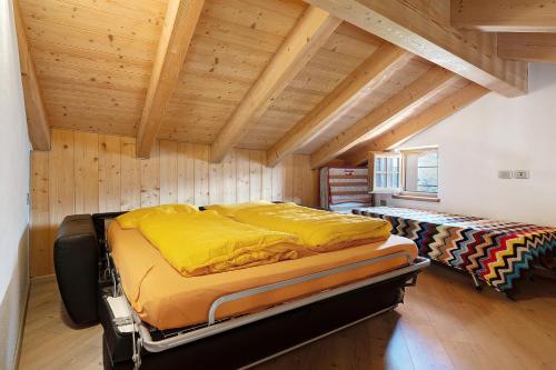 a bedroom with two beds in a room with wooden ceilings at Agritur Maso Bornie in Grauno