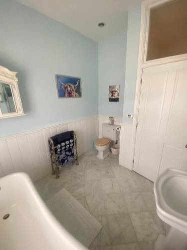 a bathroom with a tub and a toilet and a sink at Lavender Cottage in Long Bennington