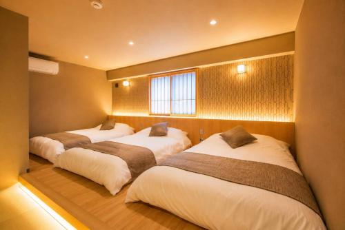 a row of four beds in a room at 緑翠-Ryokusui- in Beppu