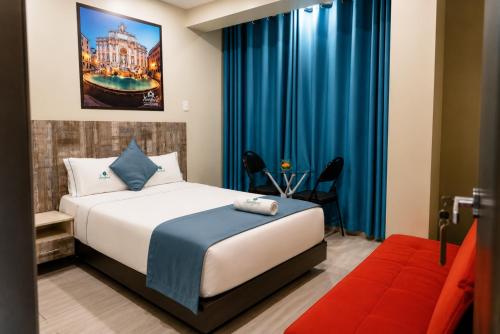 a hotel room with a bed and a couch at Hotel Konford Cañete in Imperial