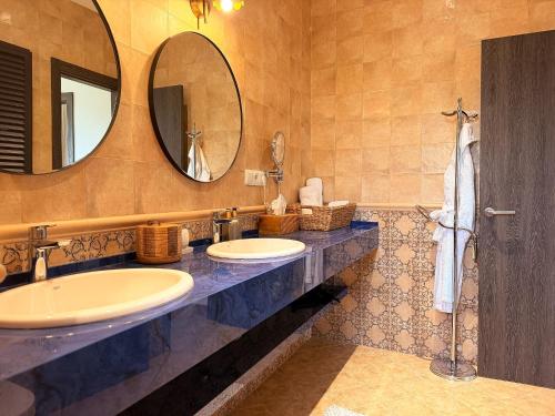 a bathroom with two sinks and a mirror at Finca Sonrisa in Alhaurín el Grande