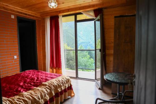 a bedroom with a bed and a large window at Guest House Mercury in Khulo