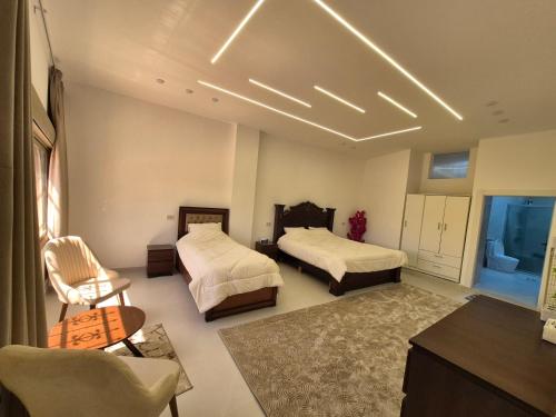 a bedroom with two beds and a table and chairs at Heart of Jerash in Jerash