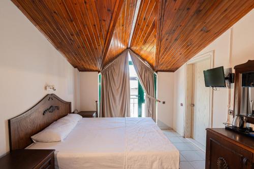 a bedroom with a large bed with a wooden ceiling at Kutberk Hotel Kemer in Kemer