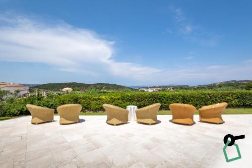 a group of chairs sitting on a patio at Hotiday Baja Sardinia Saline in Baja Sardinia