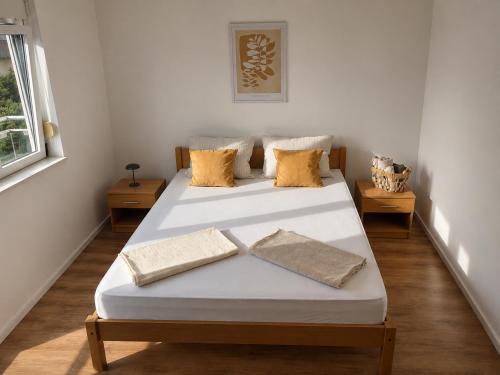 a bedroom with two beds with yellow pillows at Apartman Šarić in Neum