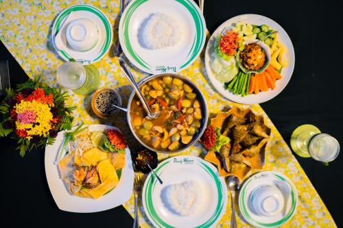 a table with plates of food on a table at Pung-Waan Resort in Sai Yok