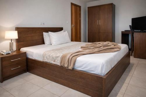 a bedroom with a large bed and a television at Hotel Murex in Brazzaville