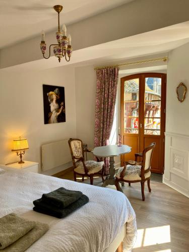 a bedroom with a bed and a table and chairs at La maison d'en haut in Josselin