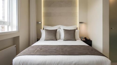 a bedroom with a large bed with white sheets and pillows at 39 Studios in London