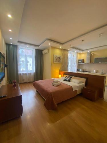 a bedroom with a large bed and a kitchen at Inn Home Apartments in Kiev Center in Kyiv