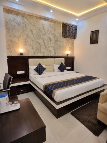 a bedroom with a large bed and a desk at Mb View taj in Tājganj