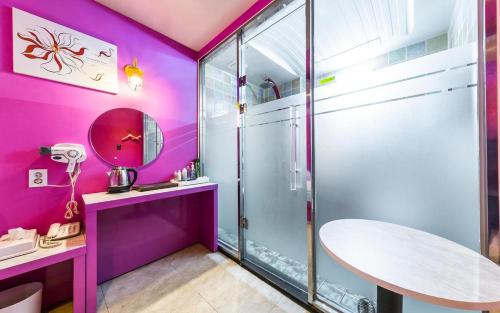 a bathroom with purple walls and a glass shower at Hotel Fiona in Seoul