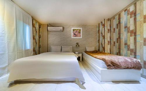 a bedroom with two beds and a window at Hotel Fiona in Seoul