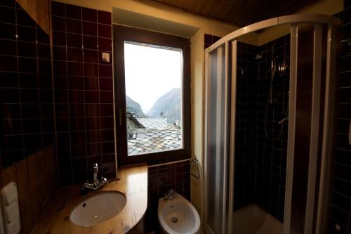 a bathroom with a window and a sink and a shower at Chalet Motta in Valtournenche