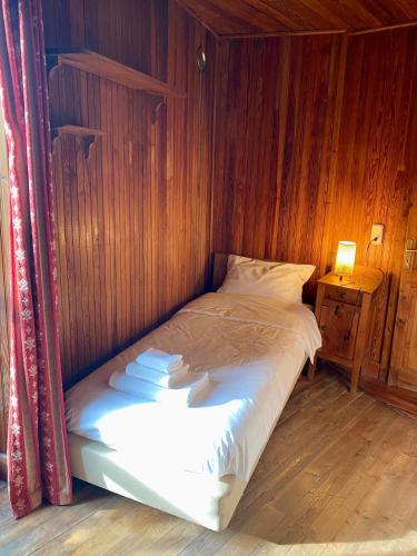 a bed in a room with a wooden wall at Chalet Motta in Valtournenche