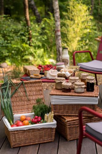 a picnic table with baskets of food and vegetables at Dacza Puchacza Hamaki in Stare Osieczno