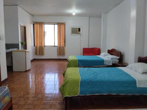 a hotel room with two beds and a window at Hostal Jireh in Manta