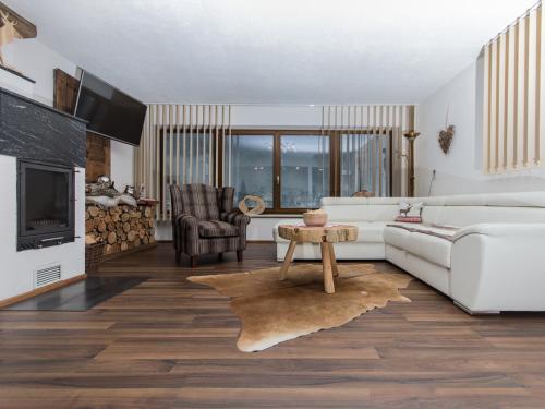ein Wohnzimmer mit einem weißen Sofa und einem Tisch in der Unterkunft Apartment Ötztal in Tumpen