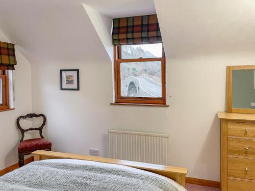 a bedroom with a bed and a window and a chair at Innish - Uk38783 in Clachan