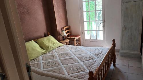 a bedroom with a bed with a white comforter and a window at La glycine in Sahune