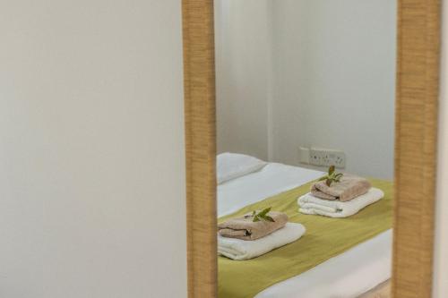a mirror with towels on top of a bed at Fig Tree Beach villa Three in Protaras