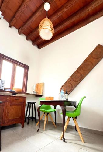 a dining room with a table and green chairs at Casa Tradicional Canaria - Chico in Garachico