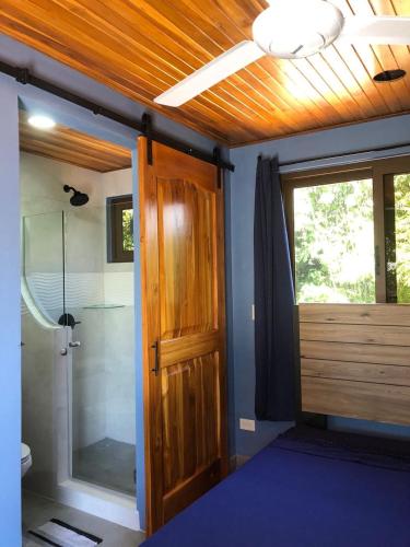 a bathroom with a shower and a wooden door at Club Fred in Punta Mala
