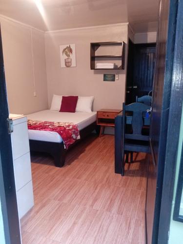 a small bedroom with a bed and a table at Apartamentos Caimán 3 in Tortuguero