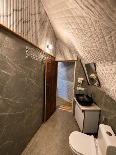 a bathroom with a toilet and a sink at Glamp by Edge Resort Premium Luxury Domes with Mountain Views in Mussoorie