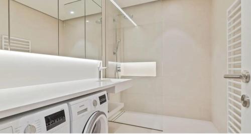 a white bathroom with a washing machine in it at Royal Hamilius Luxury 1 bed in Luxembourg