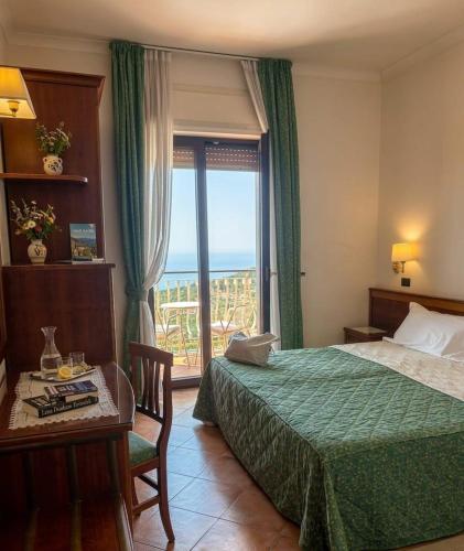 a bedroom with a bed and a table and a window at Hotel Montana in Massa Lubrense