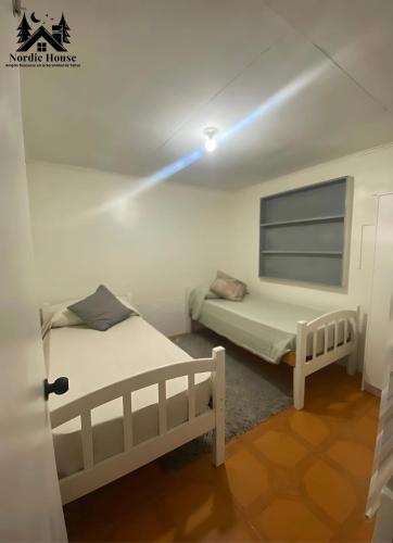 a bedroom with two beds and a light on the ceiling at Taltal - Casa Nordic in Taltal