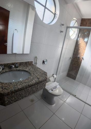 a bathroom with a toilet and a sink and a shower at Foz Presidente Economic Hotel in Foz do Iguaçu